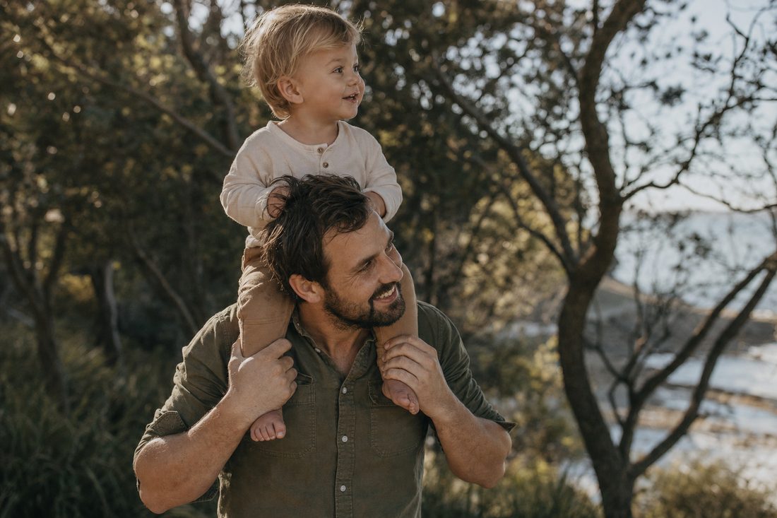 A father carrying his toddler outdoors